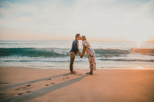 man and woman kissing on seashore in Laguna Beach United States