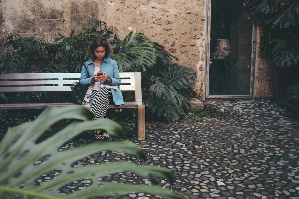 femme assise sur un banc à l’extérieur pendant la journée