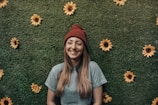 smiling woman leaning on floral wall