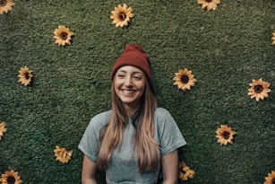 smiling woman leaning on floral wall