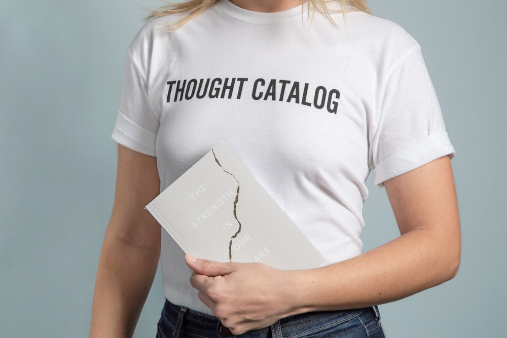 woman standing while holding white paper