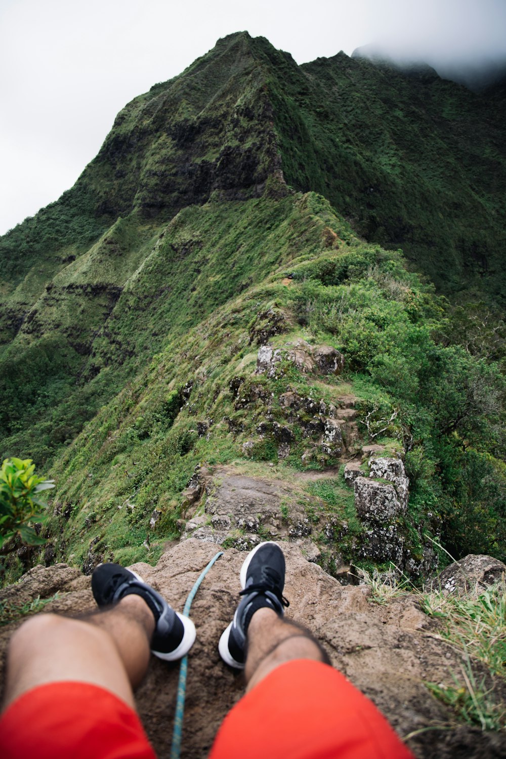 person sitting on mountain cliff