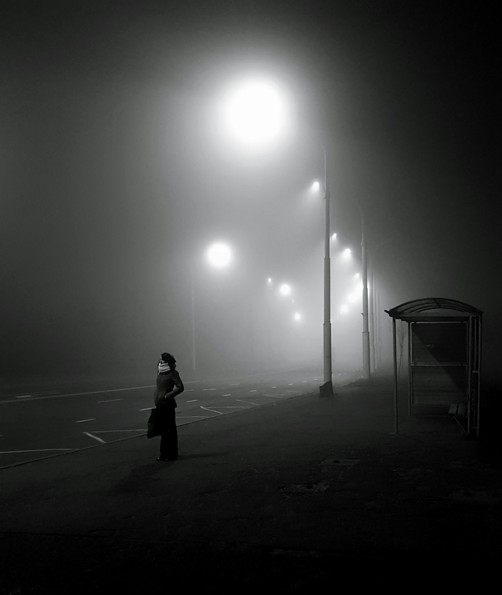 woman standing near light lamppost