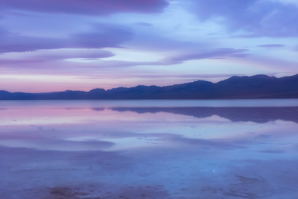 landscape photo of mountains near body of water under cloudsky