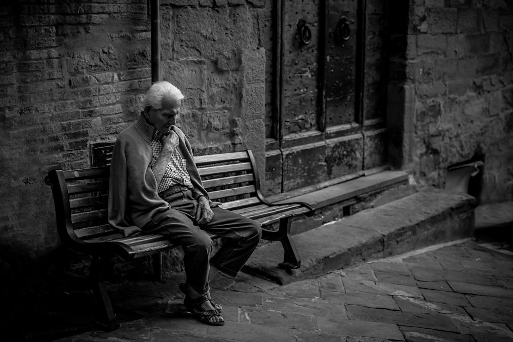 man sitting on brown bench