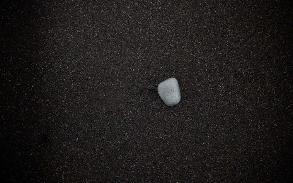 a rock sitting on top of a sandy beach