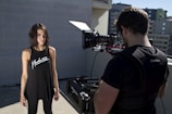 man filming standing woman