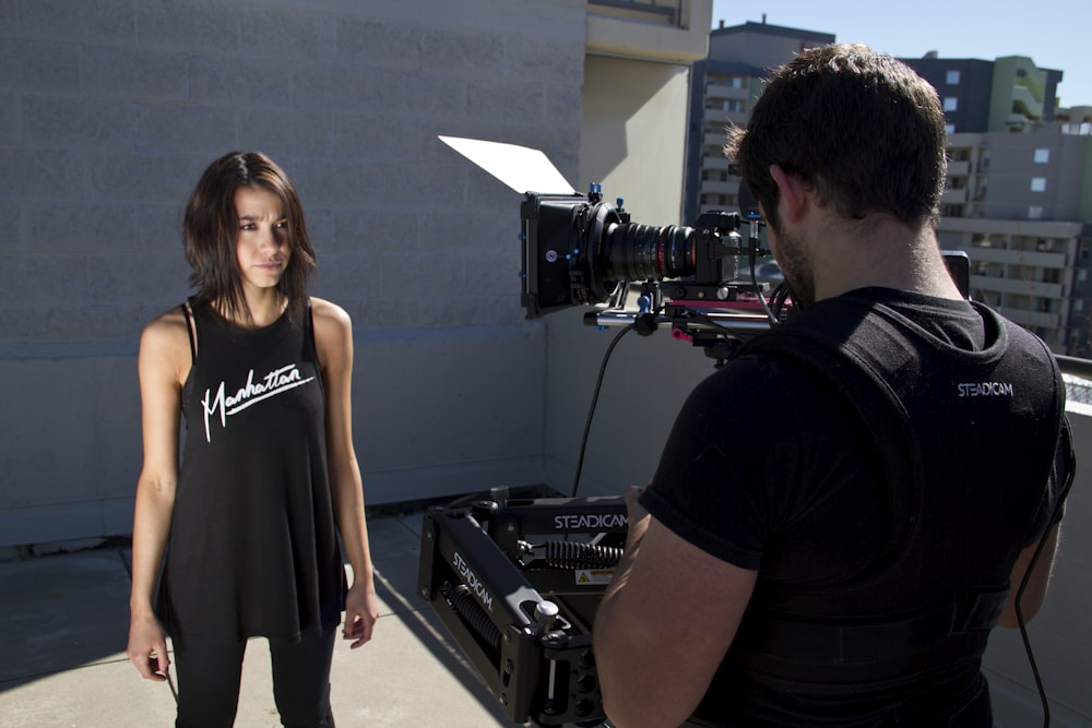 man filming standing woman