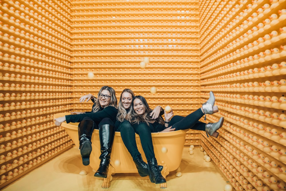 three women sitting inside bathtub