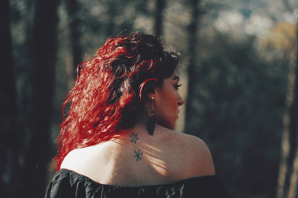 mujer mostrando su tatuaje en la espalda al aire libre