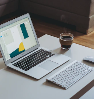 A modern laptop open on a cozy workspace with a cup of coffee nearby.