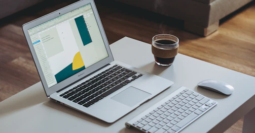 A modern laptop open on a cozy workspace with a cup of coffee nearby.