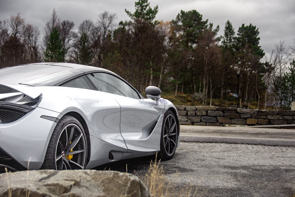 white coupe parked near forest