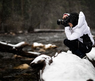 person holding camera on snow-covered surface