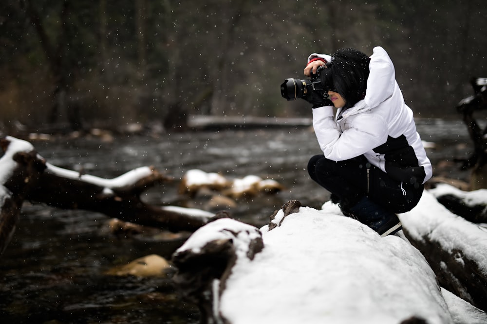 Person, die Kamera auf schneebedeckter Oberfläche hält