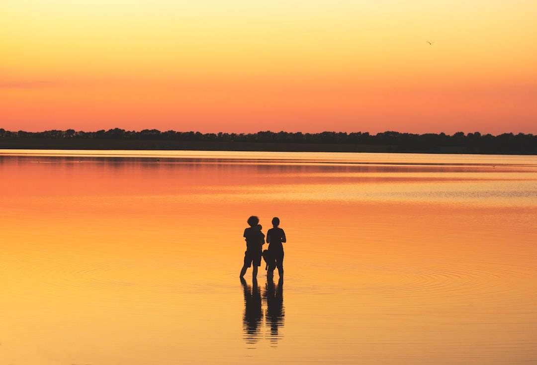 two people standing on body of water during daytime