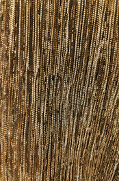 Subtle close-up of brushed gold lines on a dark textured surface, evoking refinement.