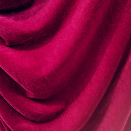 Rich, velvety fabric with deep folds and a smooth texture, creating an elegant and luxurious appearance.