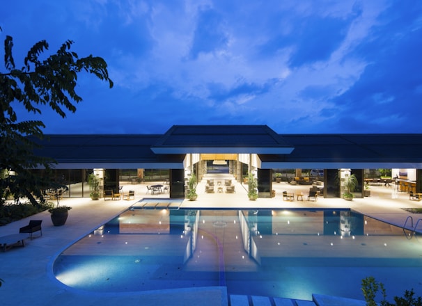 blue body of water in front of building near trees during nighttime