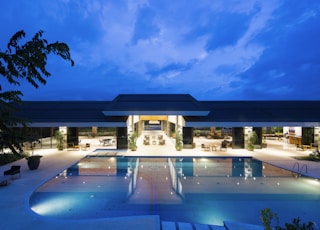 blue body of water in front of building near trees during nighttime