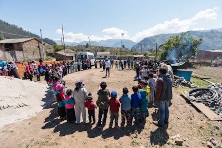 people standing forming circle near house under blue sky during daytime