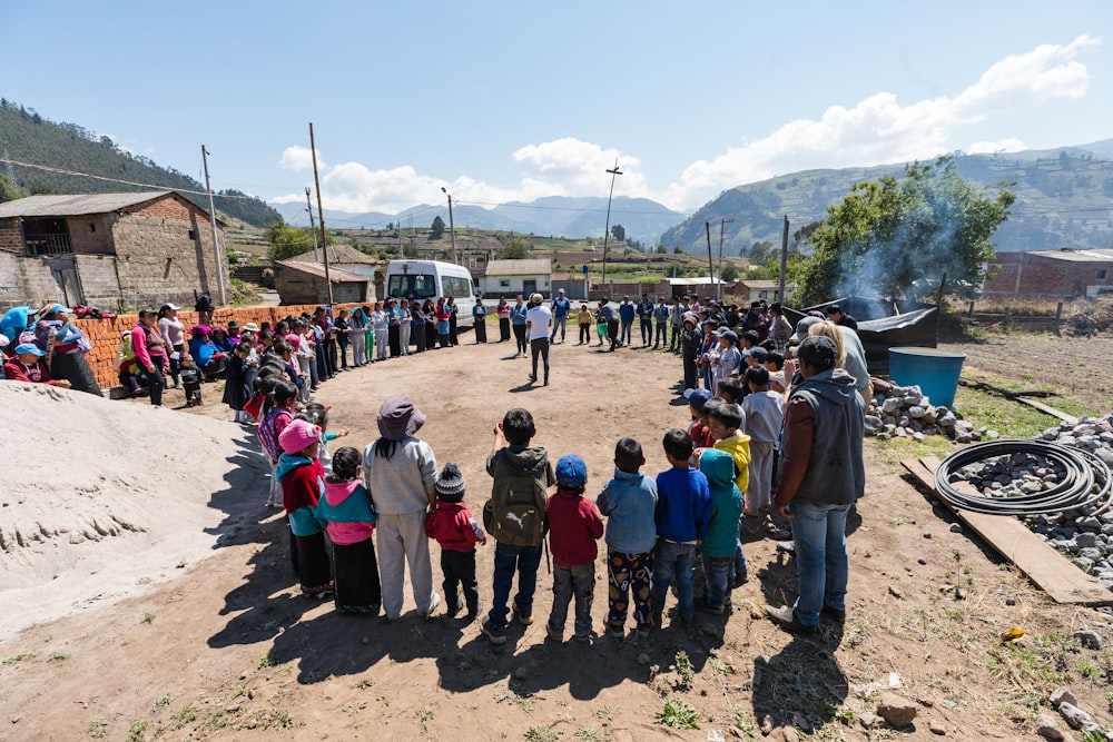 people standing forming circle near house under blue sky during daytime