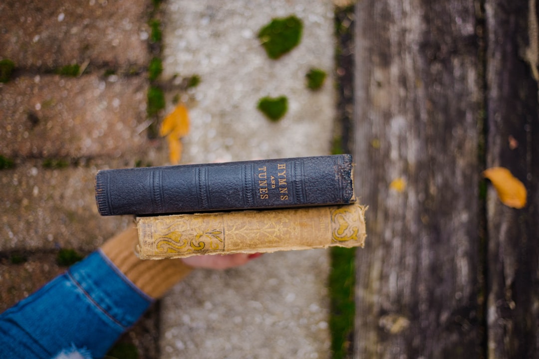 focus photography of person holding two books