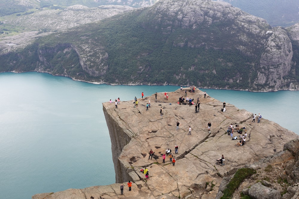 Persone in piedi sulla formazione rocciosa durante il giorno