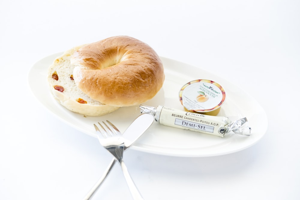 Pan en plato blanco con tenedor y cuchillo de mesa