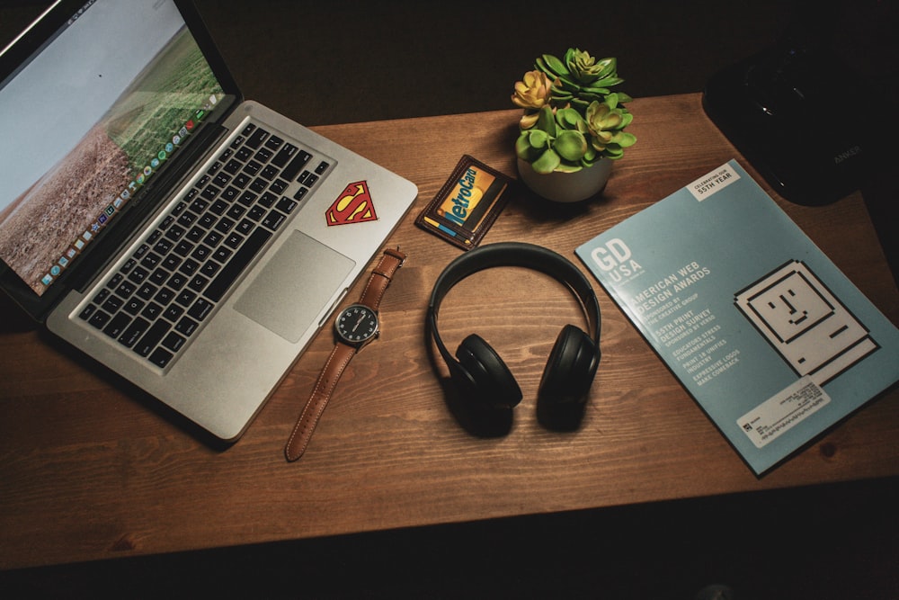 MacBook Pro beside cordless headphones