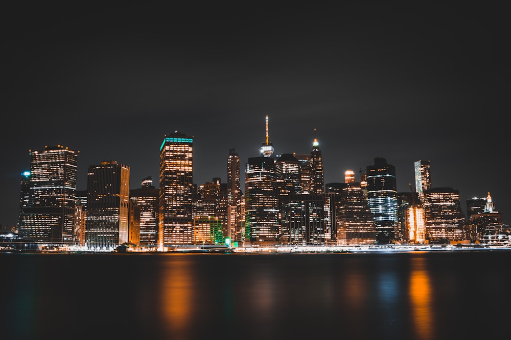 a city skyline at night with lights reflecting off the water