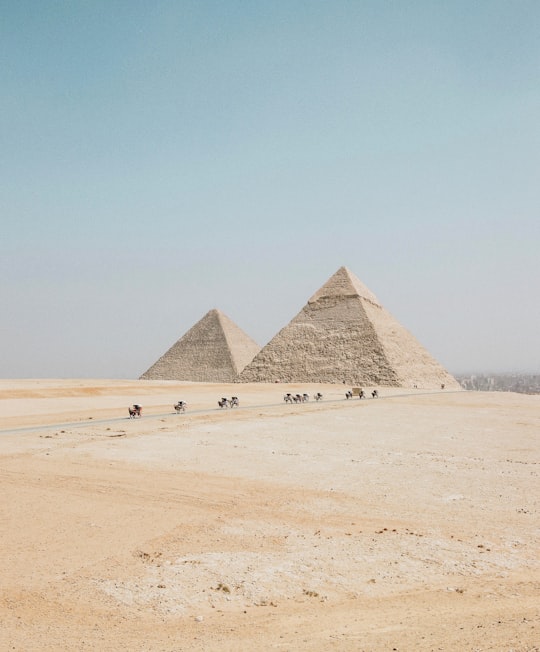 people travelling towards two pyramids in The Pyramids of Giza Egypt