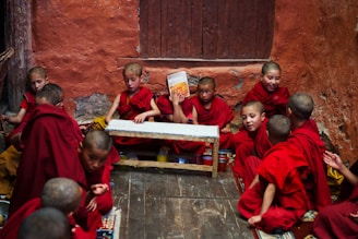 boys in red robe sitting on the floor