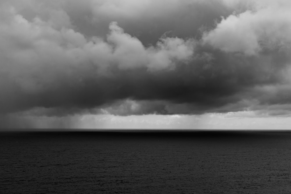 body of water under white clouds