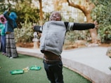 Smiling children playing in a safe, open community space.