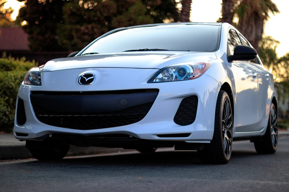 white Mazda sedan on road