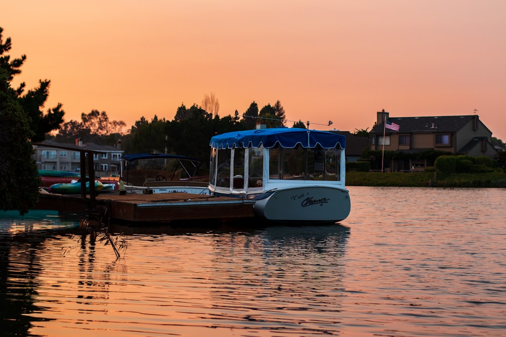 white and blue motorboat during golden hour