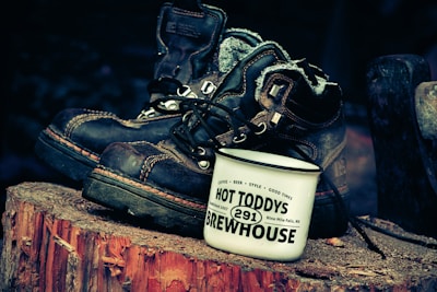 A pair of woodboots resting beside a campfire, capturing the spirit of adventure.