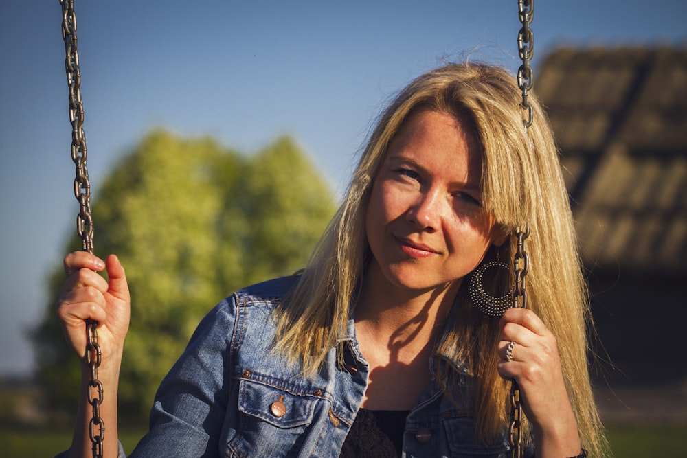 woman wearing blue denim jacket on swing