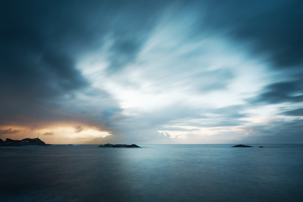 body of water under cloudy sky during daytime