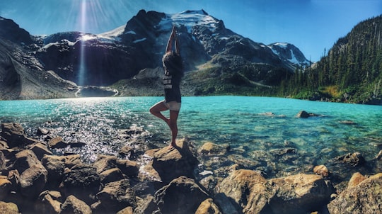 woman doing yoga pose on rock in Joffre Lakes Trail Canada