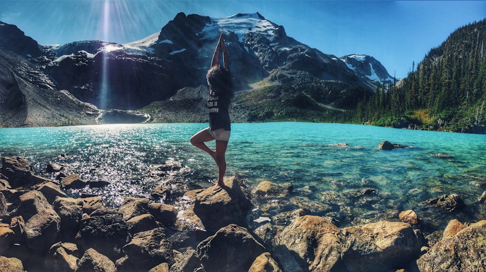 donna che fa la posa di yoga sulla roccia