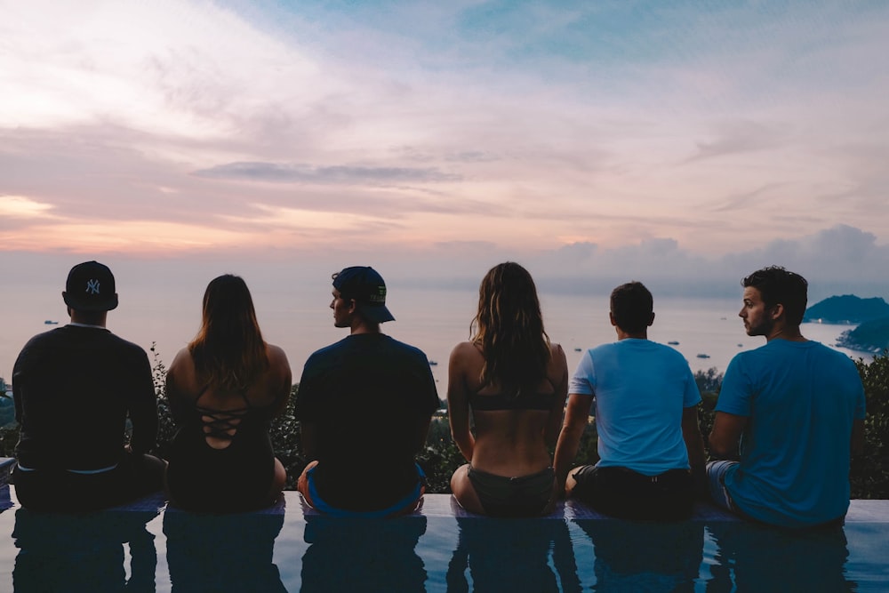 six people sitting near swimming pool