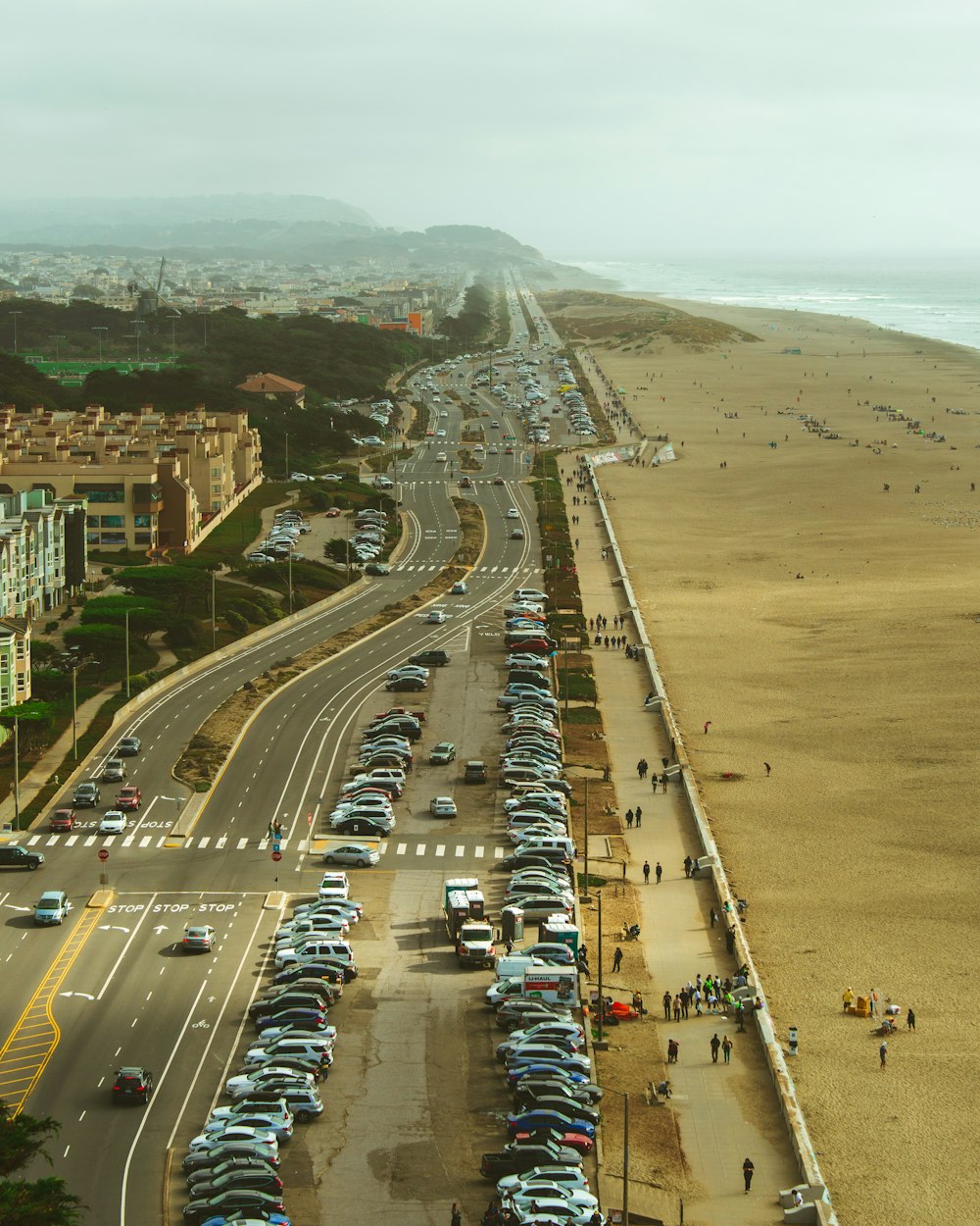 vehicles parked beside the road near people