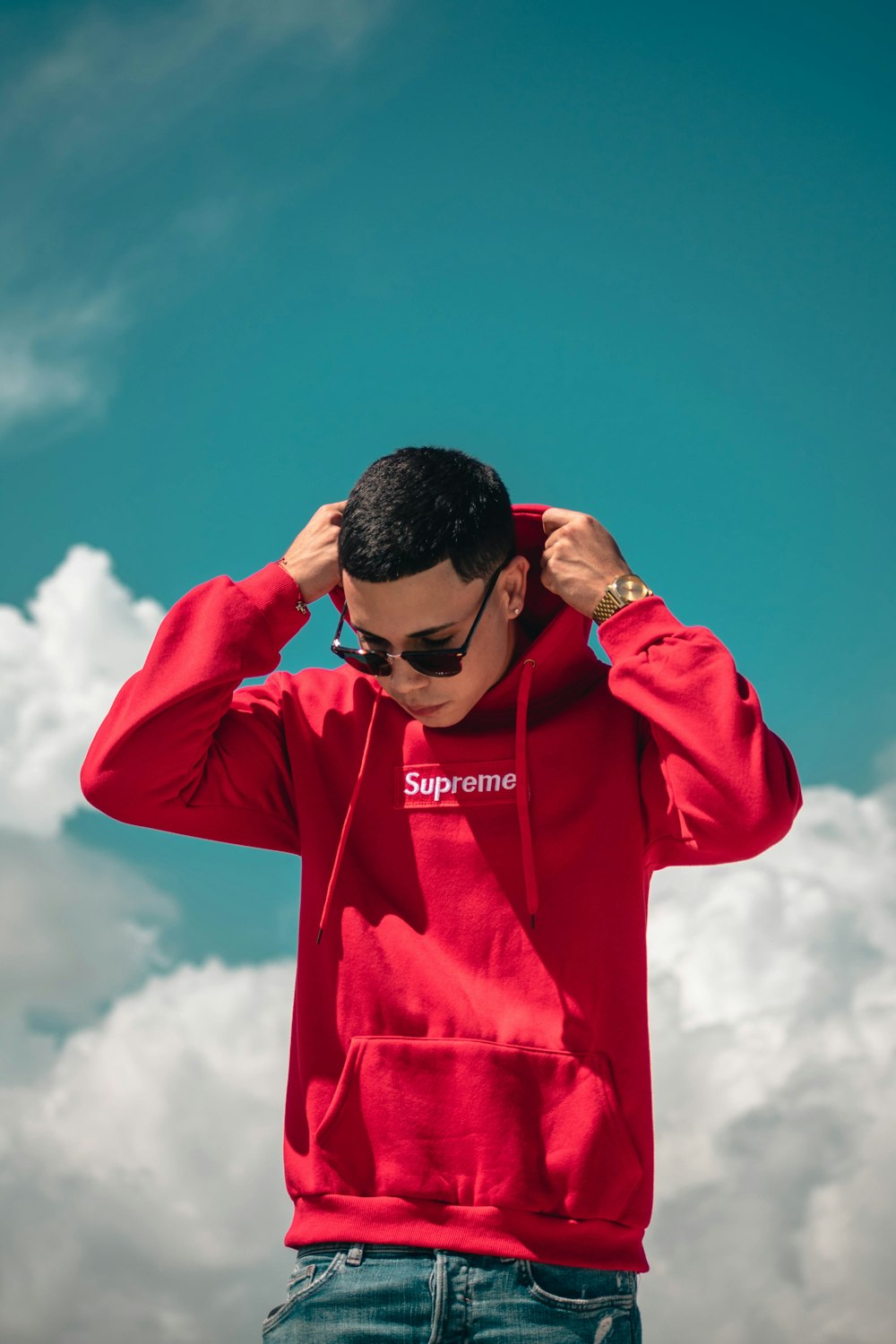 homme portant un sweat à capuche Supreme rouge