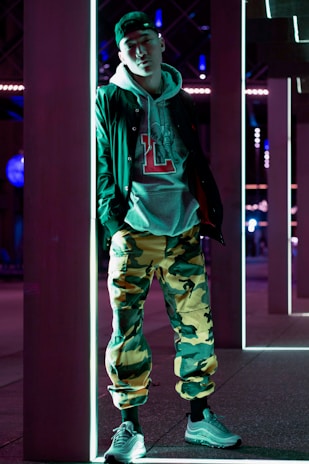 Close-up of a neon-lit streetwear jacket hanging against a dark urban backdrop.