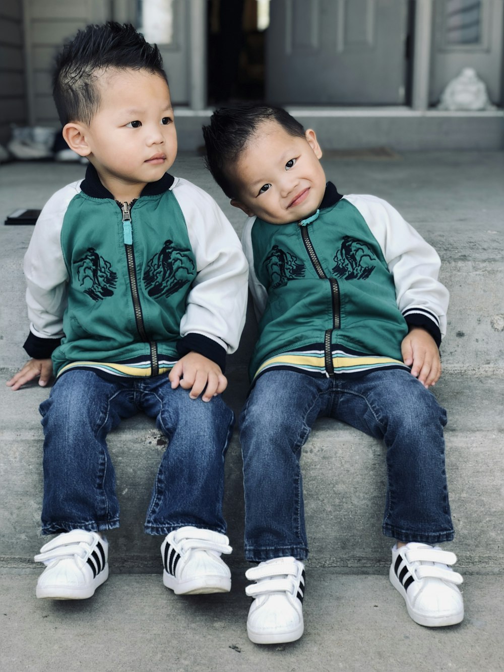 two boys sitting on curb