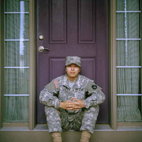woman veteran sitting in front of door of house