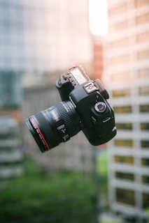 A dynamic shot of a pen mid-air above an open journal, with blurred cityscape in the background