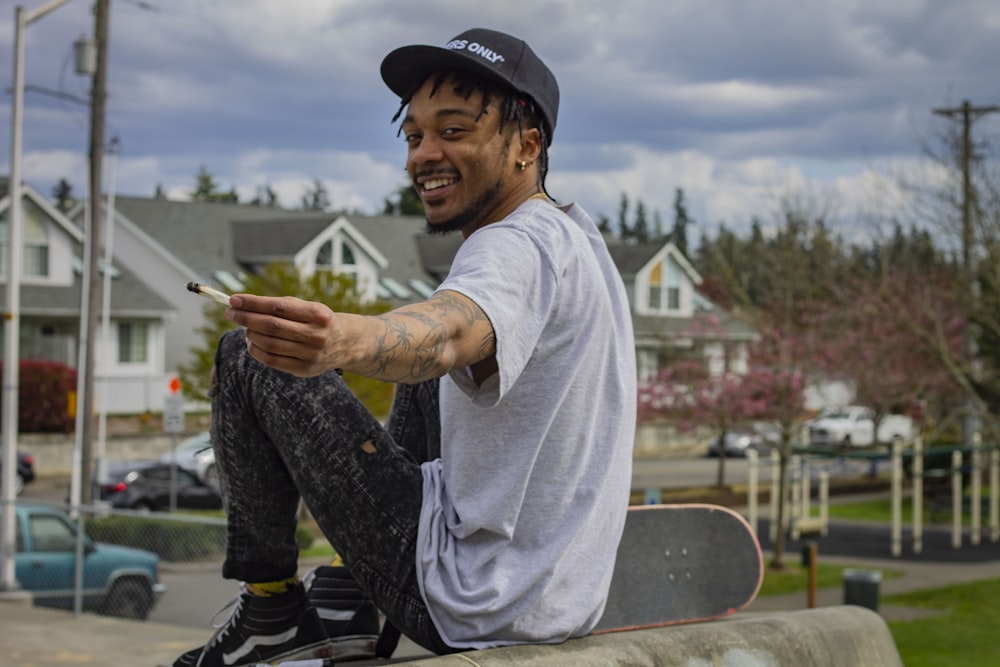 man sitting on gray pavement